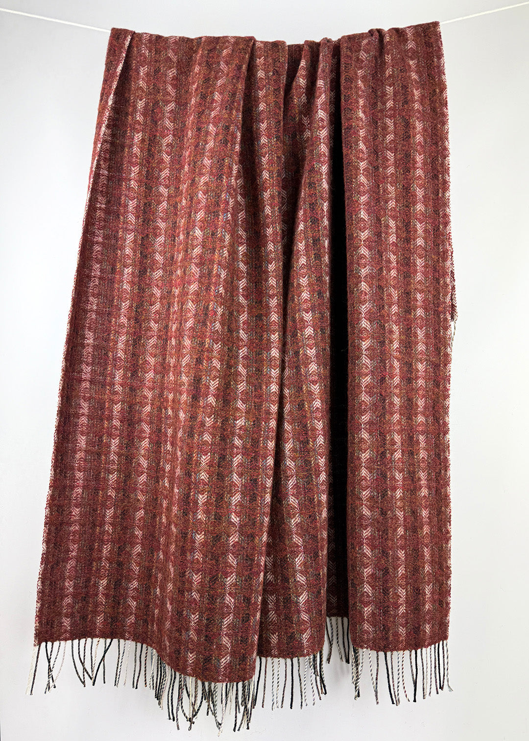 Pure wool tapestry throw in hues of red.