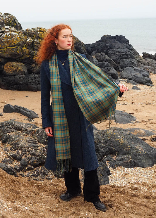 Silk scarf in douglas tartan shown on model at the beach. Scottish Textiles Showcase.