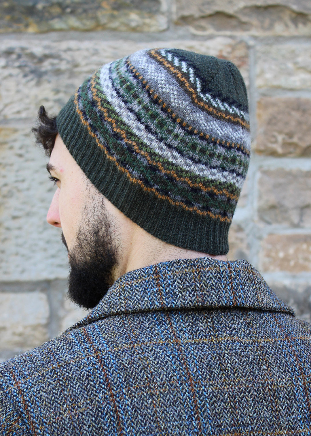 Lambwsool fairisle hat in khaki shown on model. Scottish Textiles Showcase.