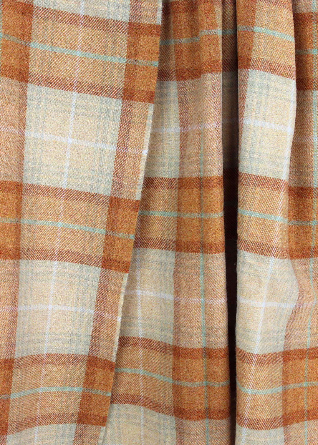Plaid wool blanket with orange and beige colours on a white background.