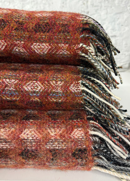 Pure wool tapestry throws in hues of red.