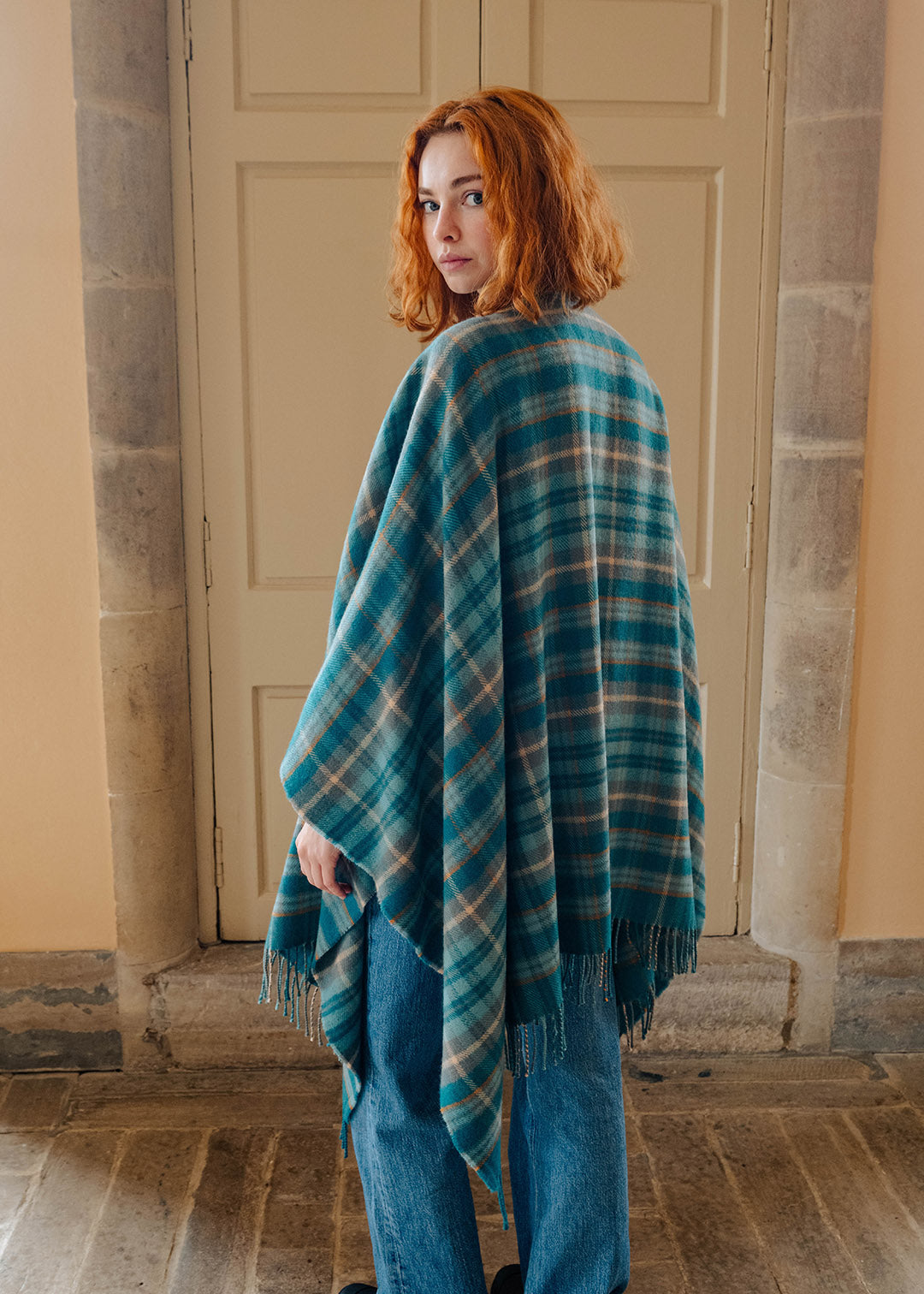 Model wearing a lambswool teal tartan serape.