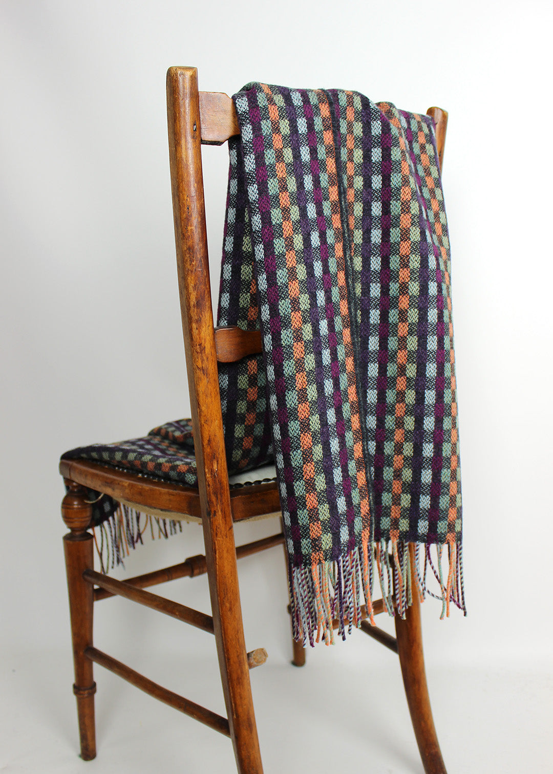 Merino wool baby blanket in check with blue, purple, green and coral.