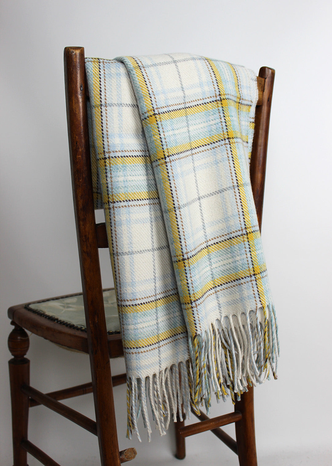 Merino wool baby blanket woven with white, pale blue and yellow.
