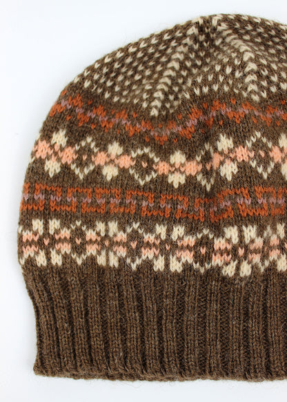 Hand knitted Fair Isle beanie hat in brown with contrasting details.