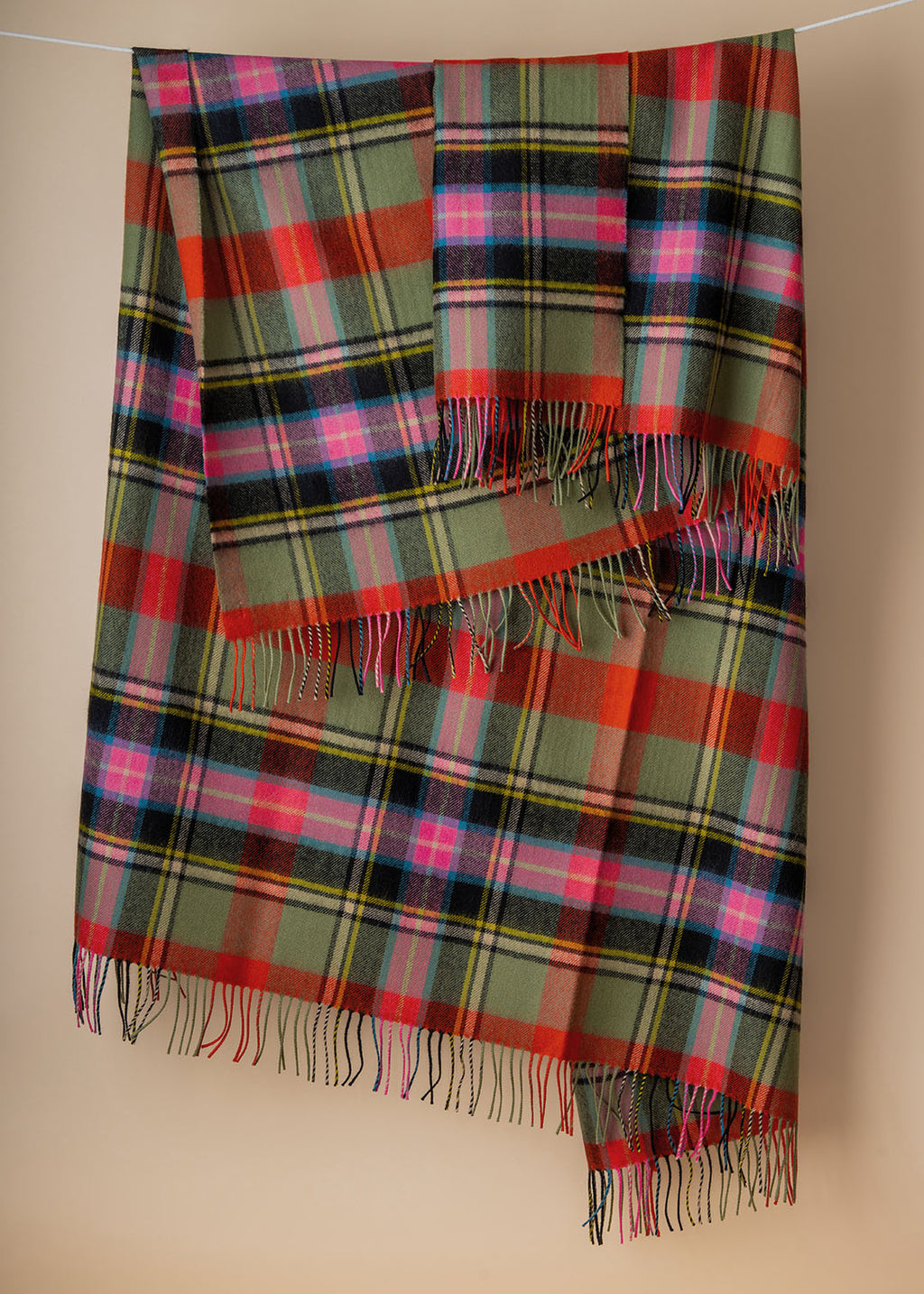 Lambswool tartan blanket woven in the vibrant greens, pinks and orange of the Bruce of Kinnaird tartan. Made in the Scottish Borders. 