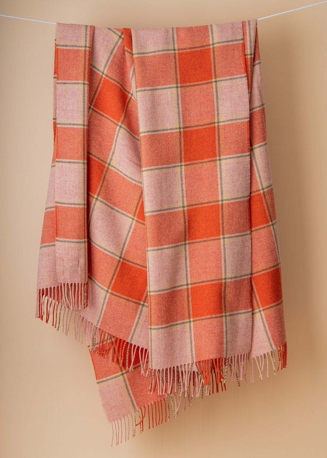 Scottish lambswool throw in coral pink and orange Elizabeth Pirrie colourway.