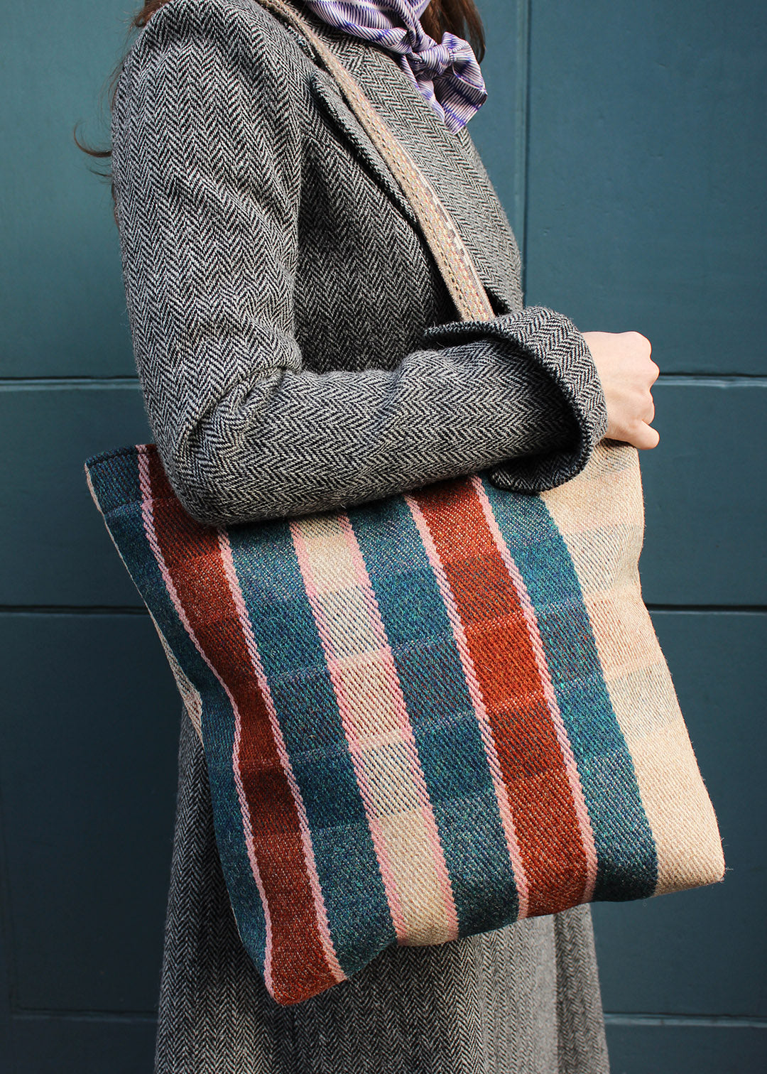 The Flora bag is woven in a teal, rust, oatmeal and pale pink check.