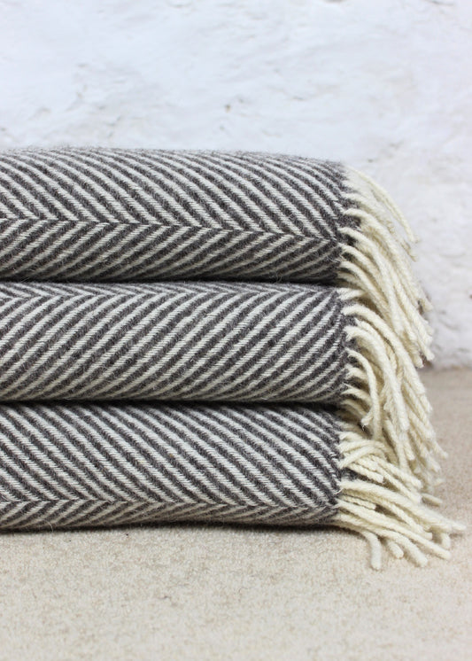 Grey blanket with tassels and geometric zig zag pattern. Scottish Textiles Showcase.