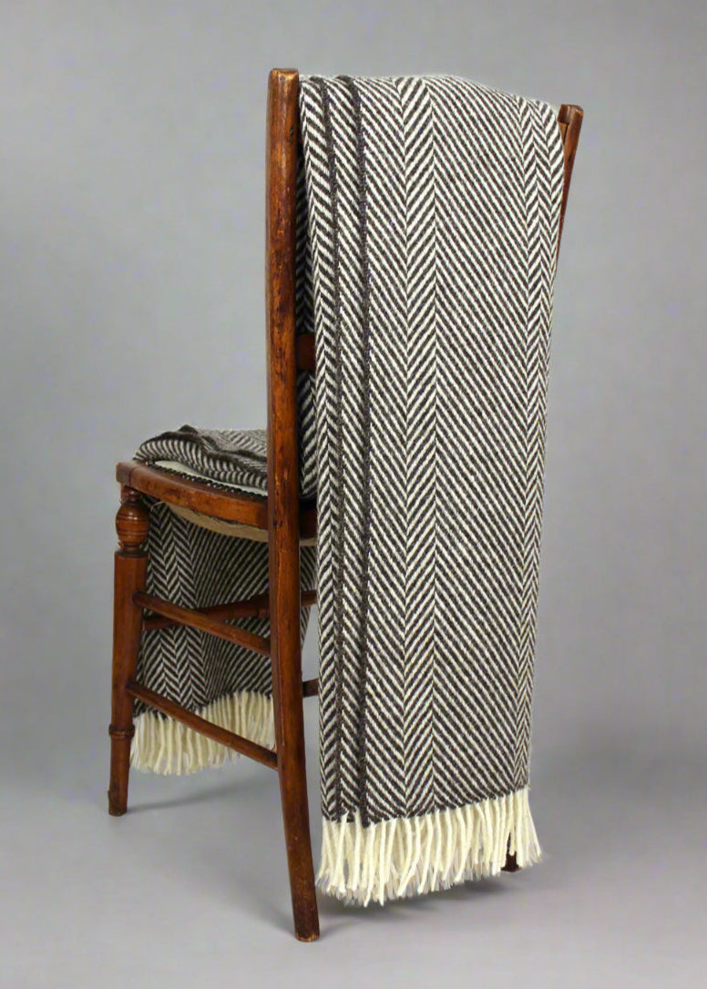 Jacob blanket brown shown on a chair. Scottish Textiles Showcase.
