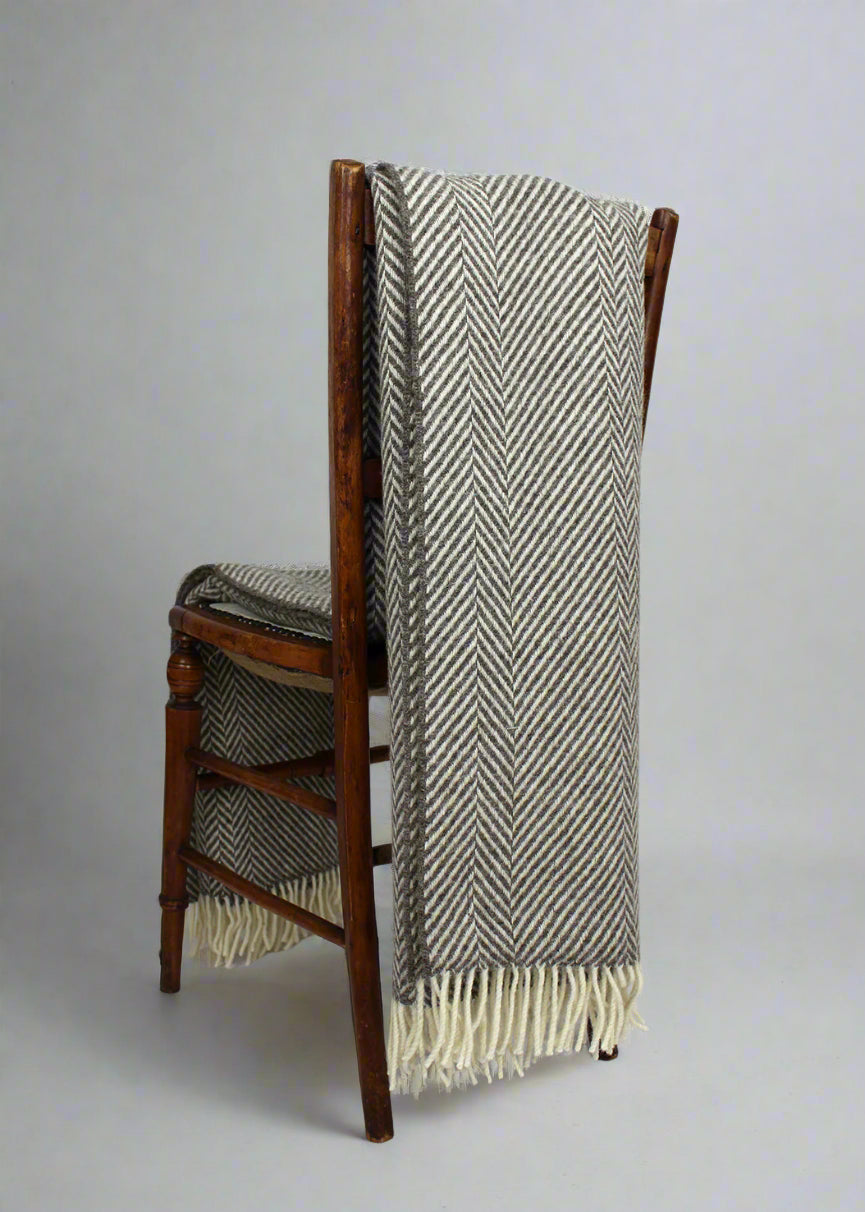 Grey Jacob throw on a chair. Scottish Textiles Showcase.