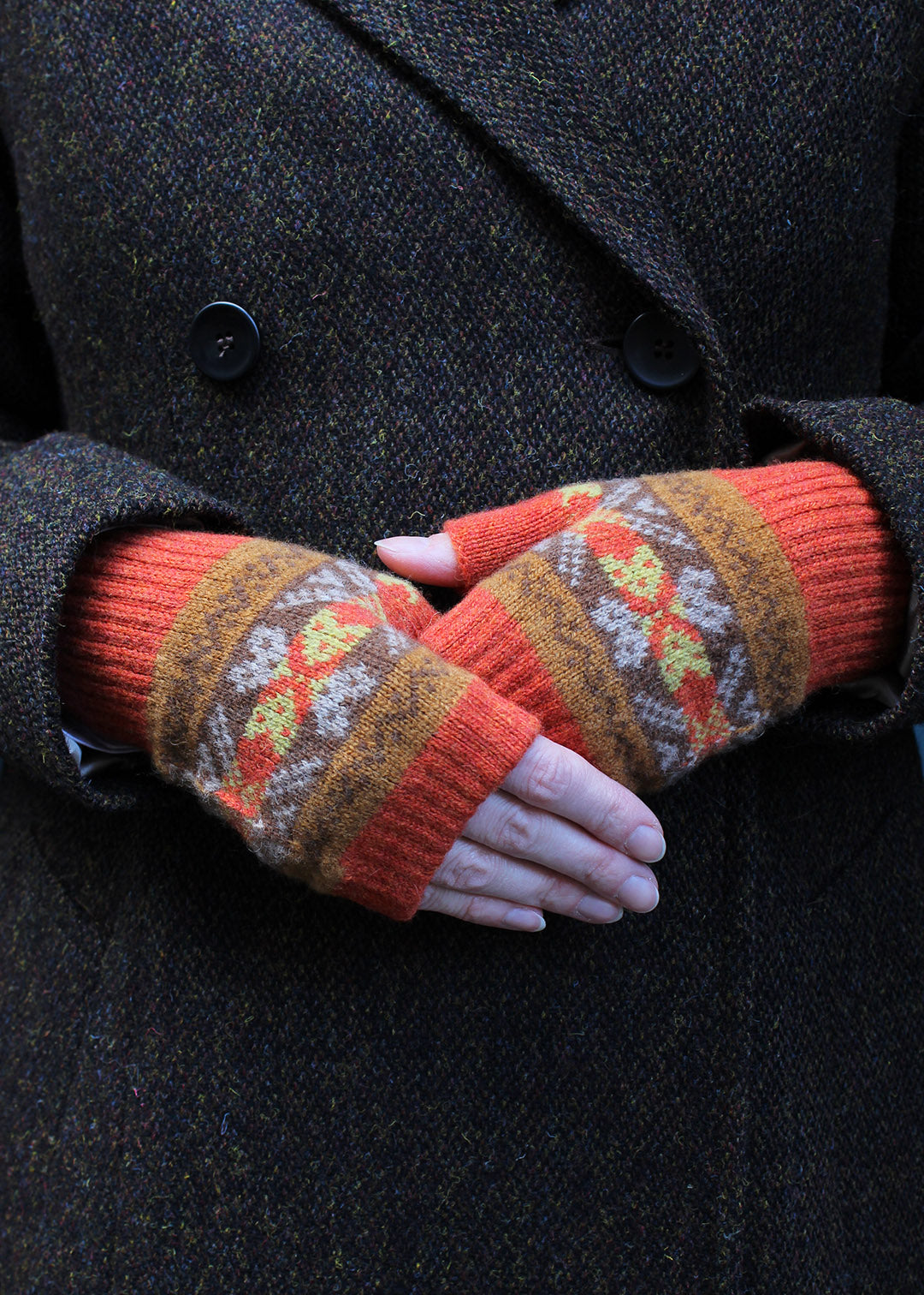 Lambswool May mittens in spice colourway shown on model.