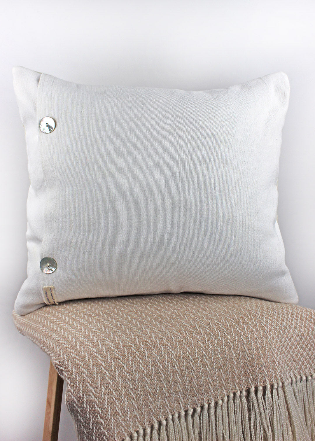 Limited edition, handwoven wool cushion in natural cream and blush pink