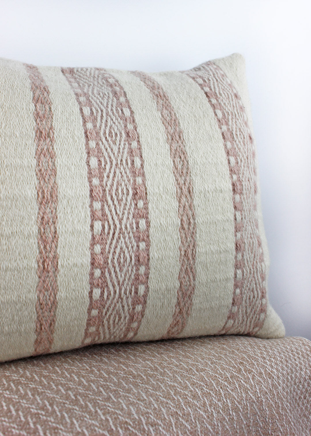 Limited edition, handwoven wool cushion in natural cream and blush pink