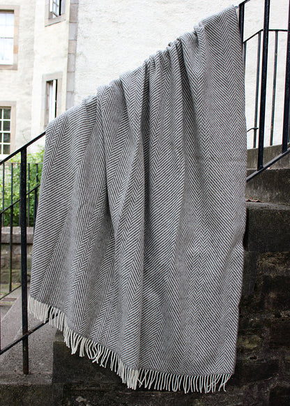 Grey blanket with tassels and geometric zig zag pattern. Scottish Textiles Showcase.