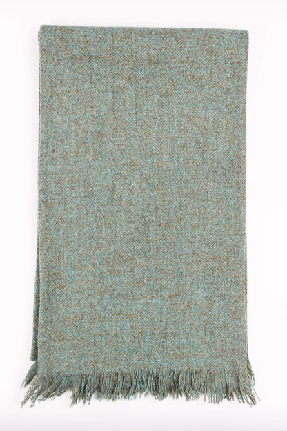 Soft taupes and sea green blues blend together in a subtle herringbone pattern in the Haar scarf, made from luxurious Harris Tweed® and lined with the softest Scottish cashmere in a stunning sea green.