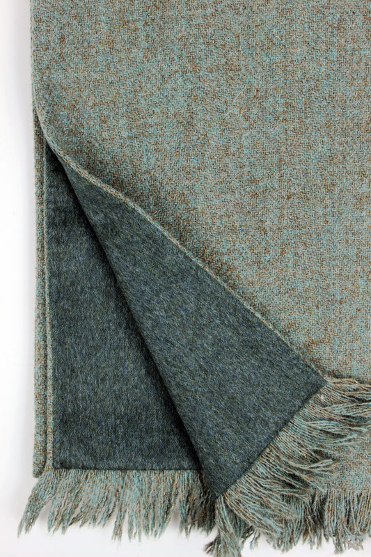 Soft taupes and sea green blues blend together in a subtle herringbone pattern in the Haar scarf, made from luxurious Harris Tweed® and lined with the softest Scottish cashmere in a stunning sea green.