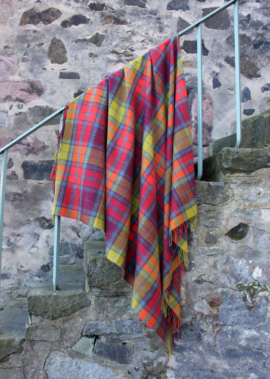 Lambswool tartan blanket woven in the bright reds. yellows and greys of the Buchanan Berry tartan. Made in the Scottish Borders. Scottish Textiles Showcase.