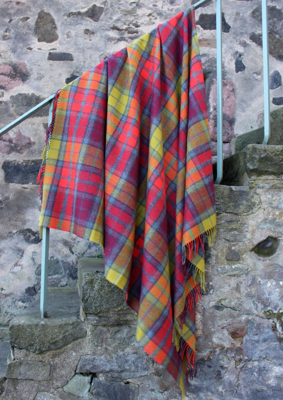 Lambswool tartan blanket woven in the bright reds. yellows and greys of the Buchanan Berry tartan. Made in the Scottish Borders. Scottish Textiles Showcase.