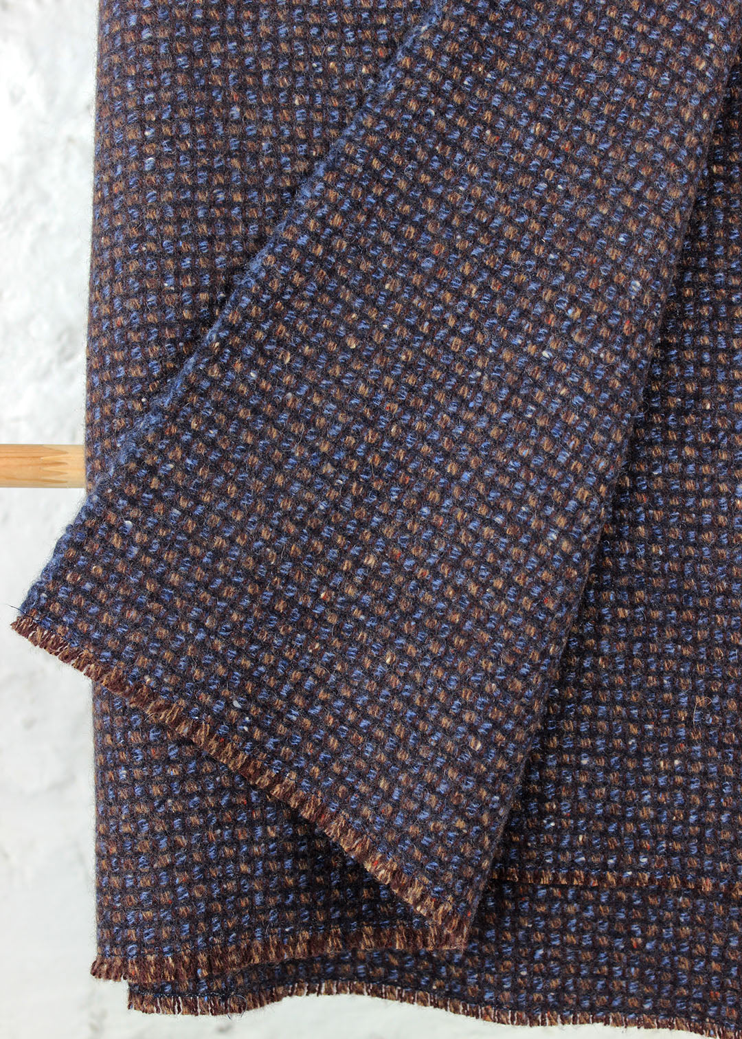 Pure cashmere throw in a subtle waffle texture woven in blues, browns and maroon