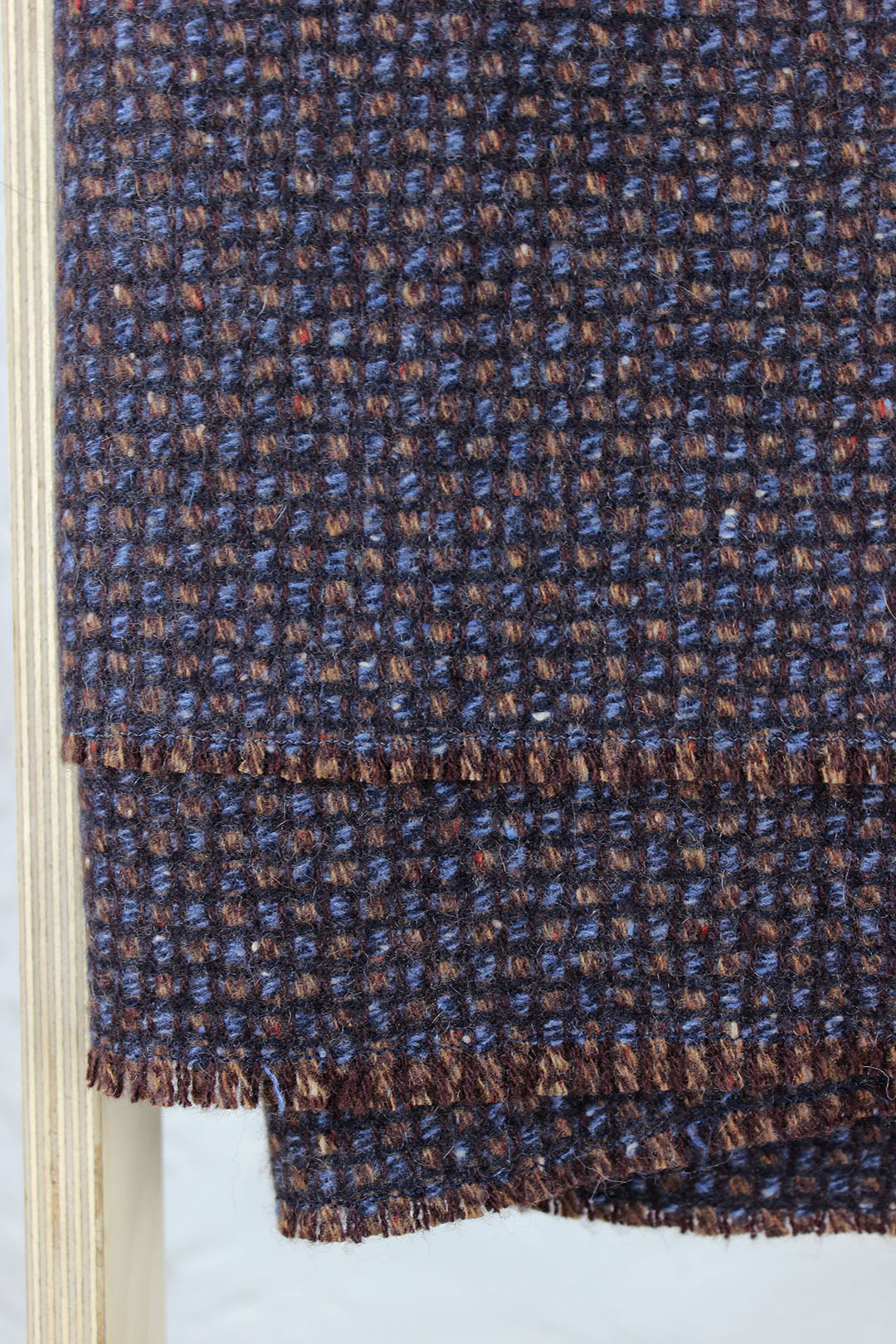 Pure cashmere throw in a subtle waffle texture woven in blues, browns and maroon