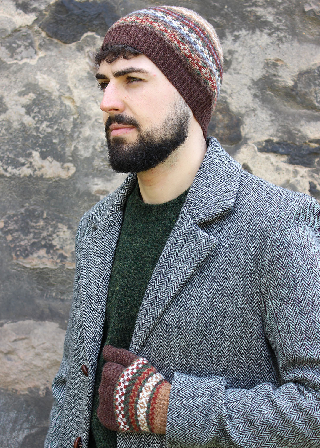 Lambwsool fairisle hat in earth shown on model. Scottish Textiles Showcase.