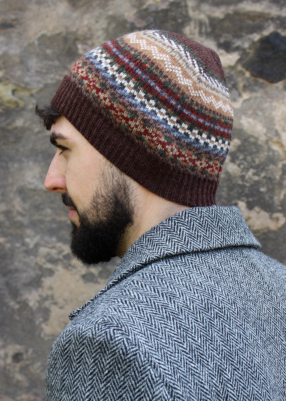 Lambwsool fairisle hat in earth shown on model. Scottish Textiles Showcase.