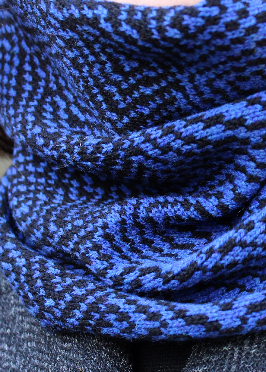 Merino lambswool neck warmer in Persian blue and black with a design inspired by map contours.