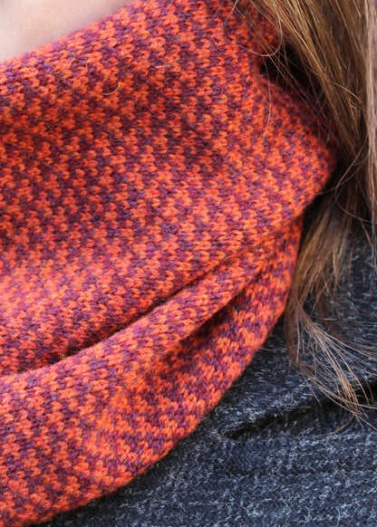 Merino lambswool neck warmer in rust and burgundy with a design inspired by the Hebridean sea on the crossing to the Isle of Harris.