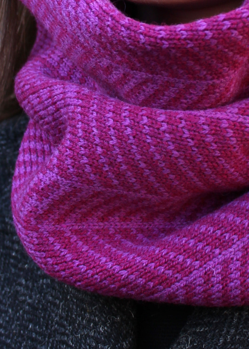 Merino lambswool neck warmer in shades of magenta and cerise with a design inspired by the glass roof of Waverley Railway Station in Edinburgh.