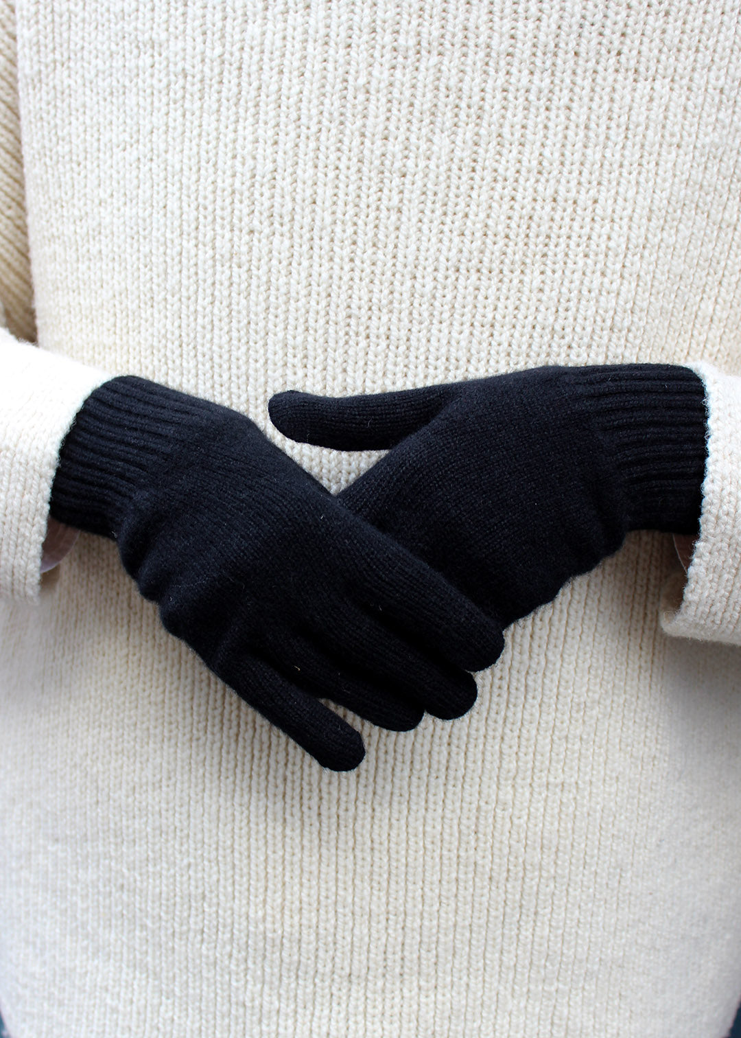 Pair of black cashmere gloves on model.