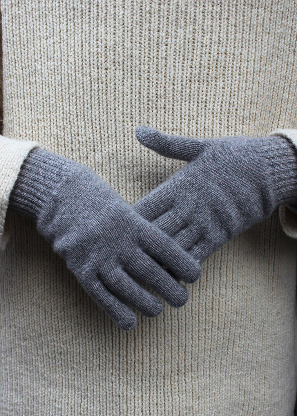 Pair of grey cashmere gloves on model.