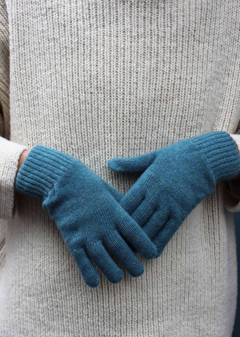 Pair of ocean cashmere gloves on model.