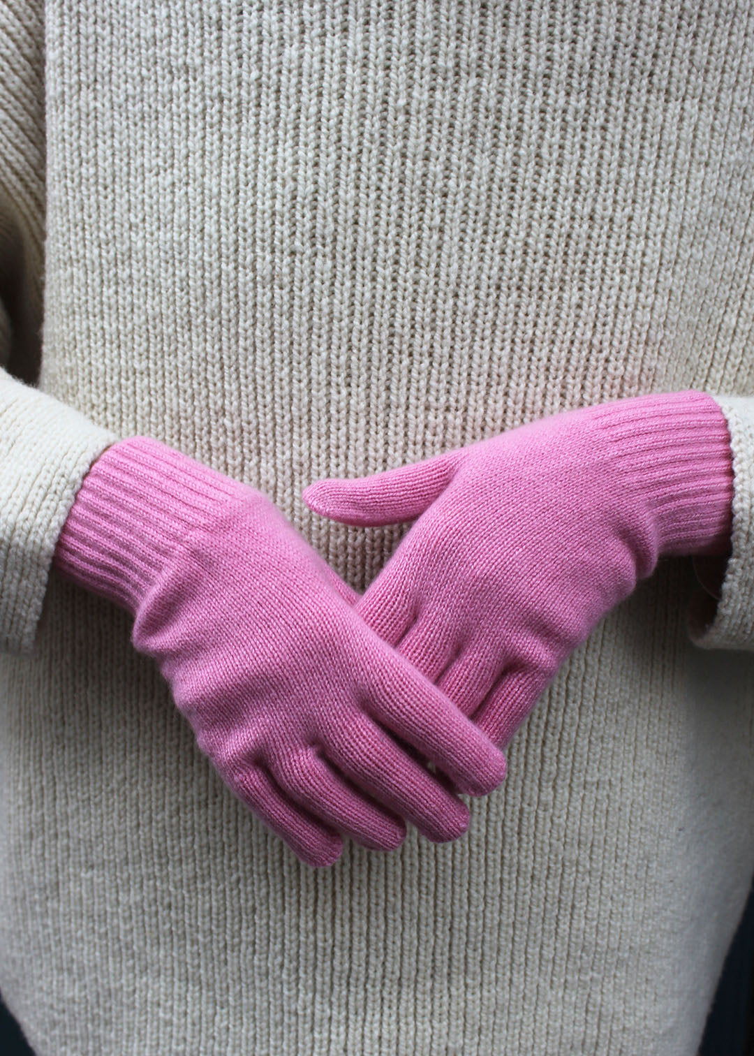 Pair of pink cashmere gloves on model.
