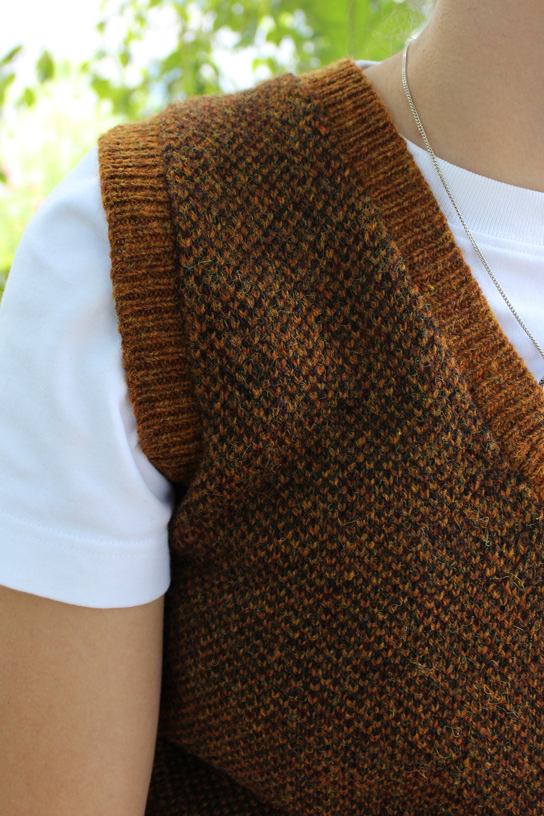 Shetland knitted tank top in burnt umber, with a v-neck. Close up detail.