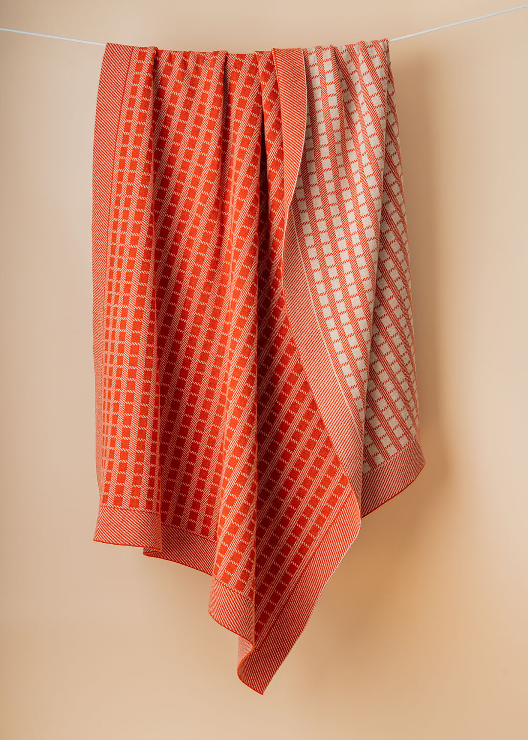 Jacquard knit lambswool blanket in furnace shown on model.