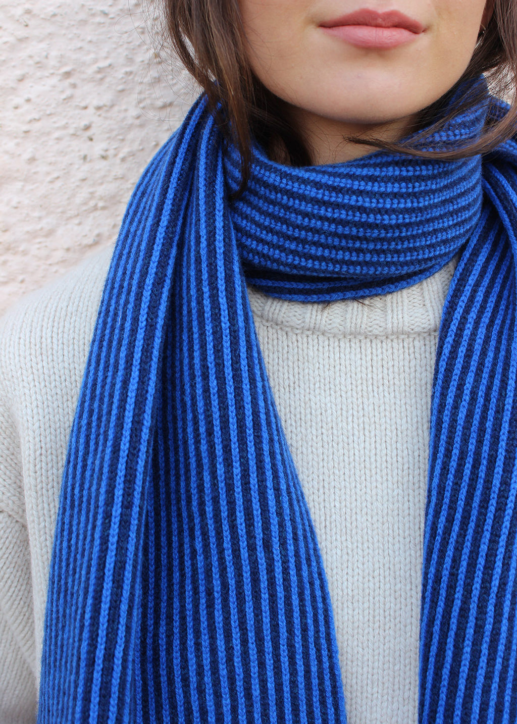 Lambswool cobalt blue and navy striped scarf shown on model. Scottish Textiles Showcase.