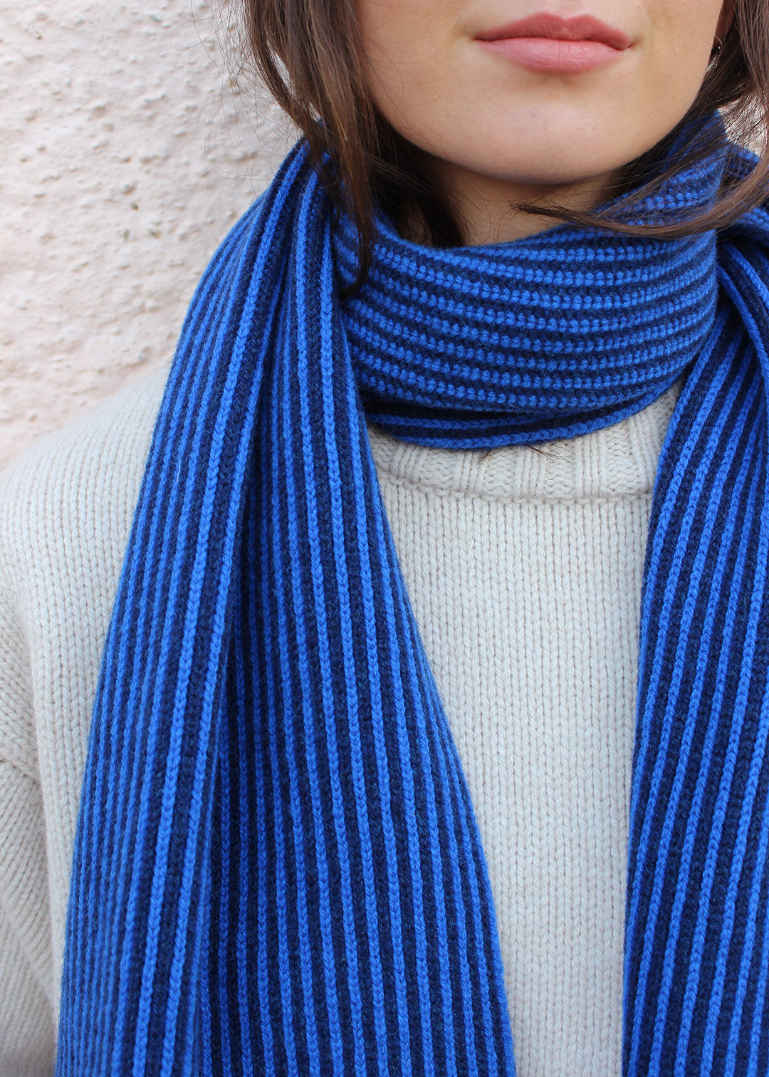 Lambswool cobalt blue and navy striped scarf shown on model. Scottish Textiles Showcase.