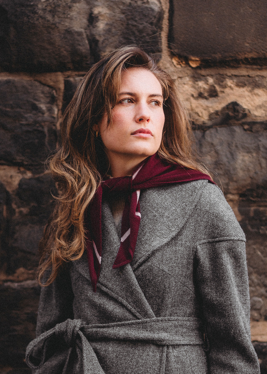 Knitted triangle scarf in deep damson red with a pale pink stripe.
