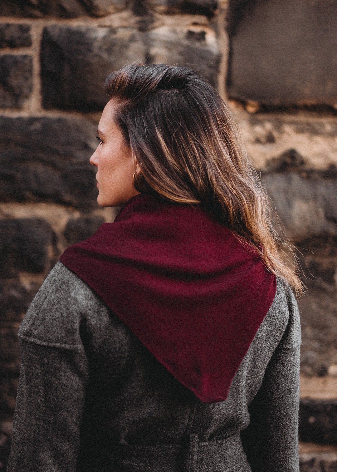 Knitted triangle scarf in deep damson red with a pale pink stripe.