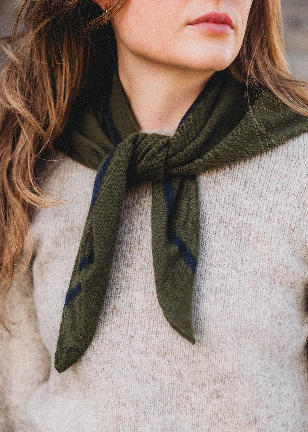 Knitted triangle scarf in dark loden green with a navy stripe.