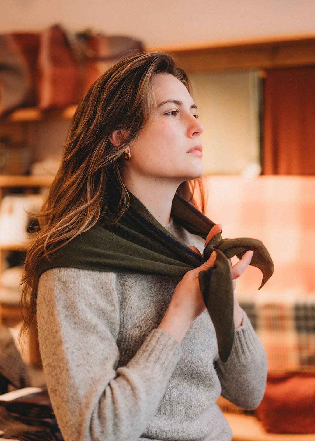 Knitted triangle scarf in dark loden green with a navy stripe.
