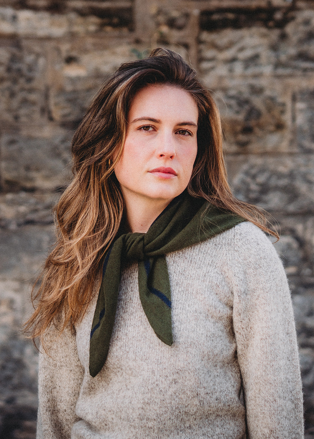 Knitted triangle scarf in dark loden green with a navy stripe.