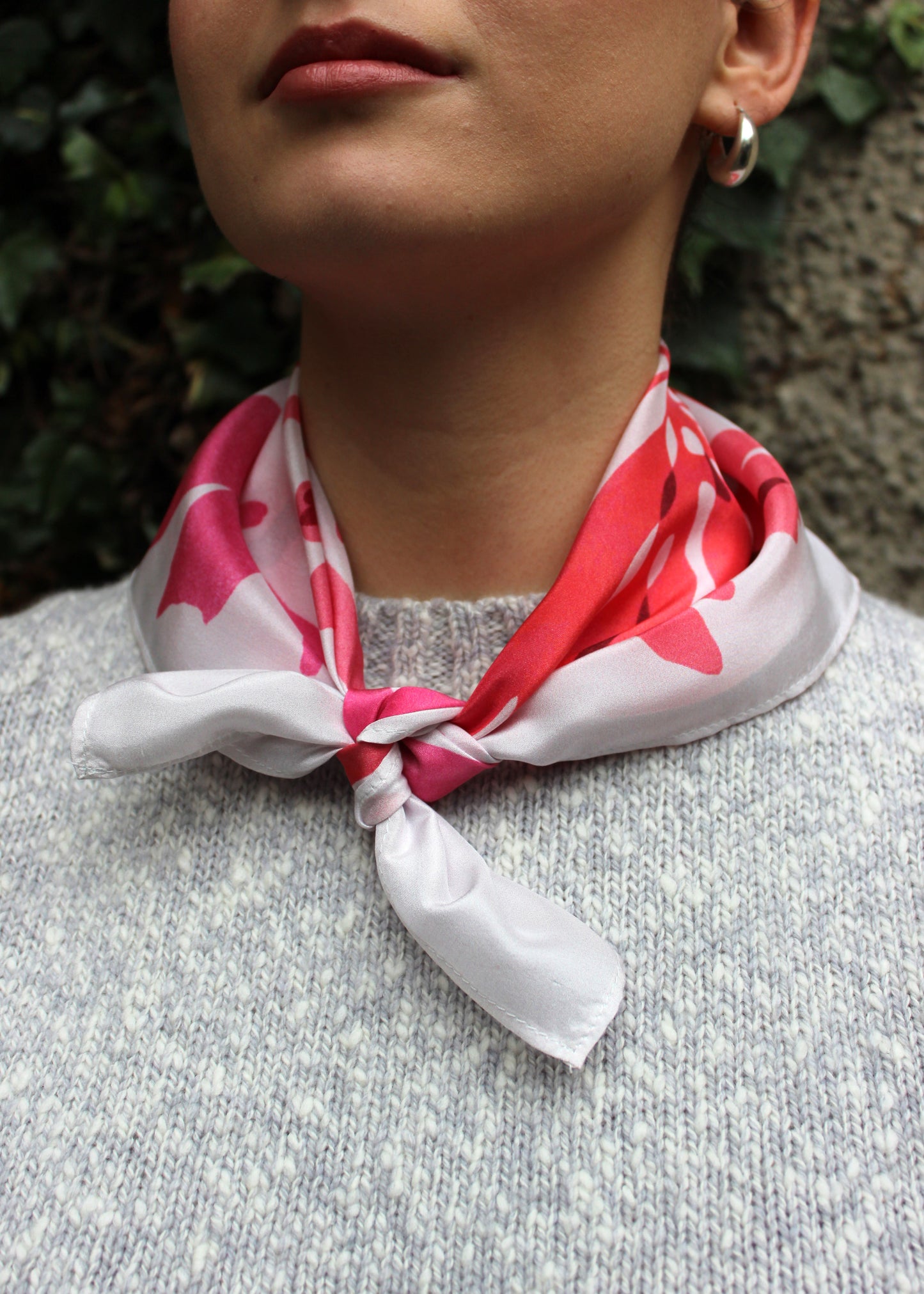 The Dulse silk scarf features a collaged print of dulse seaweed in vibrant pinks on a pearl white background.