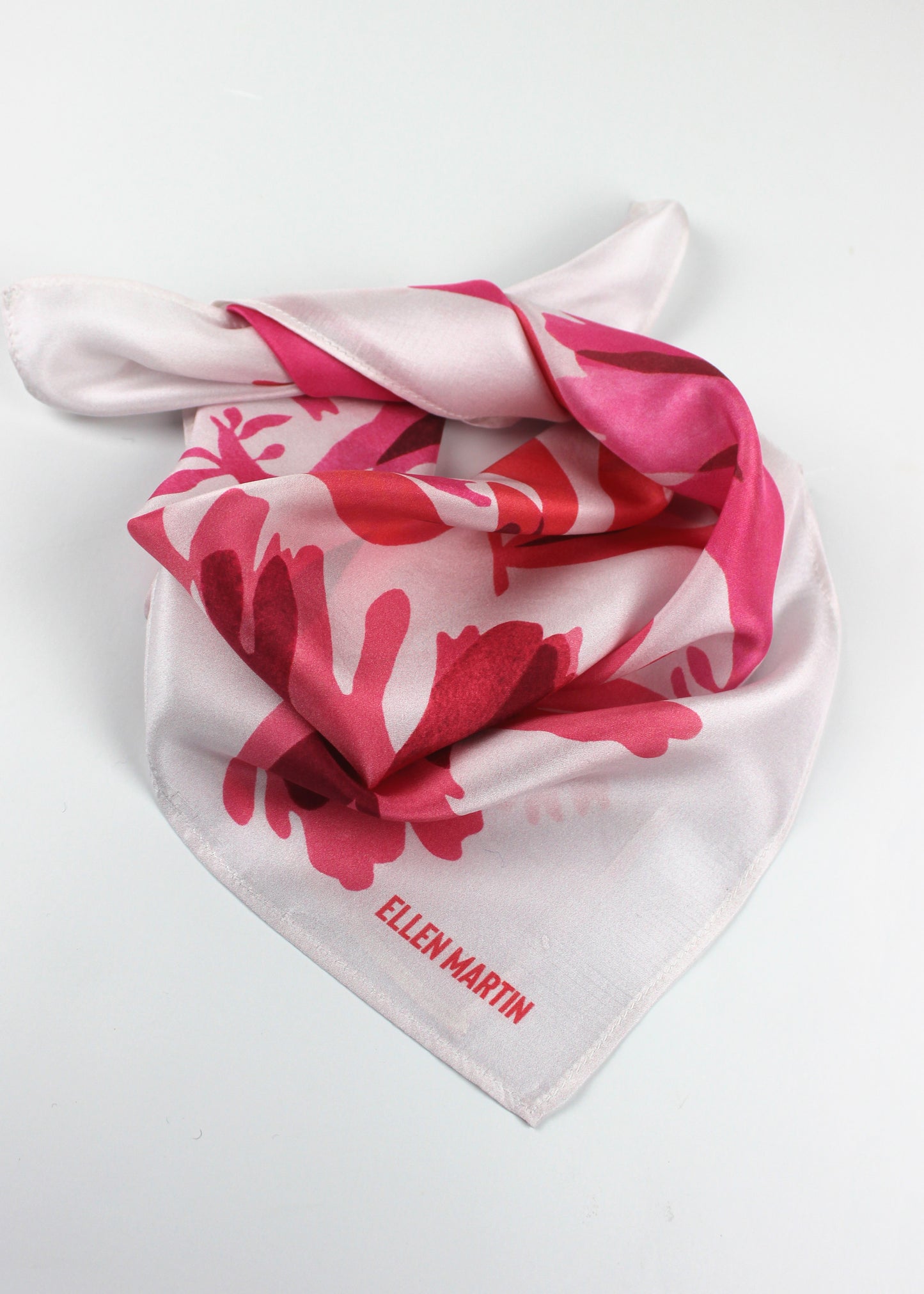 The Dulse silk scarf features a collaged print of dulse seaweed in vibrant pinks on a pearl white background.