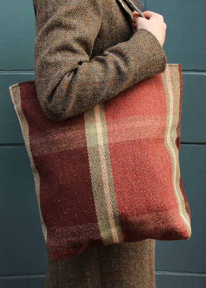 The Dunvegan bag is woven in an oversized check in burgundy, rusty red and sage green.