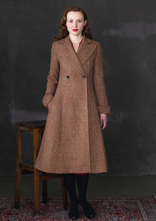 Harris Tweed ladies coat in a rust check, shown on model.