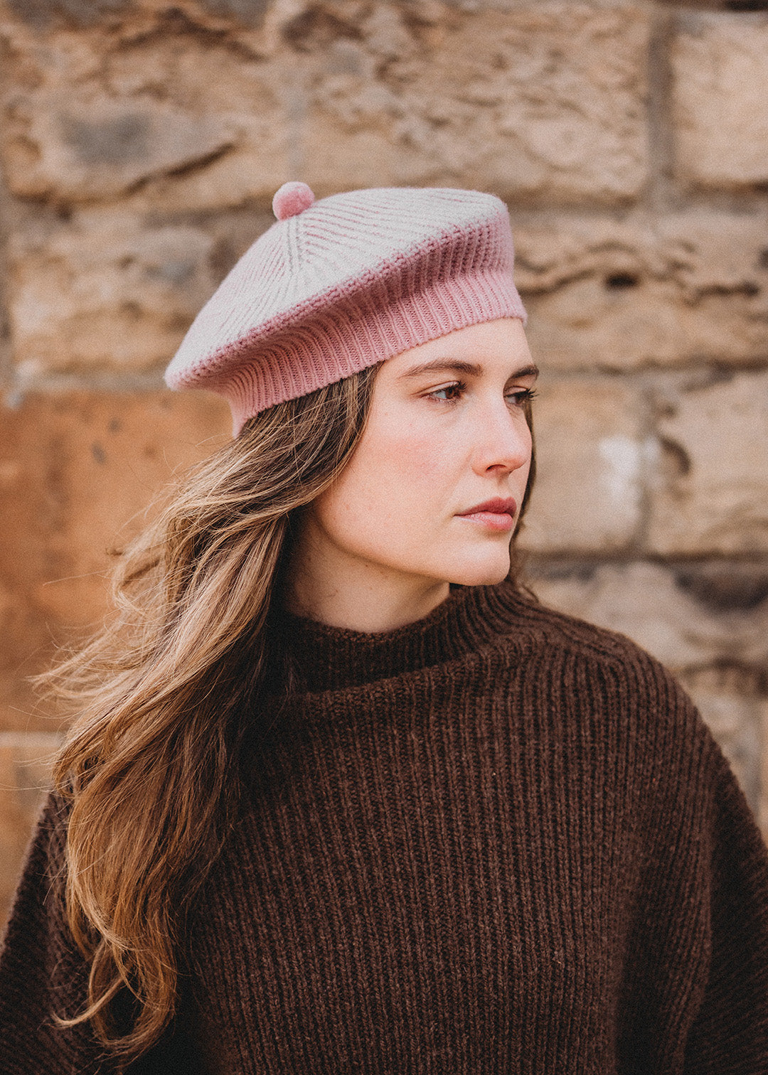 Lambswool beret in calamine pink, finished with a felted pom-pom on top.