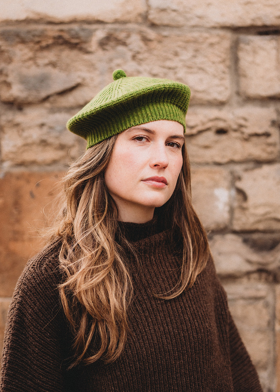 Lambswool beret in moss green, finished with a felted pom-pom on top.