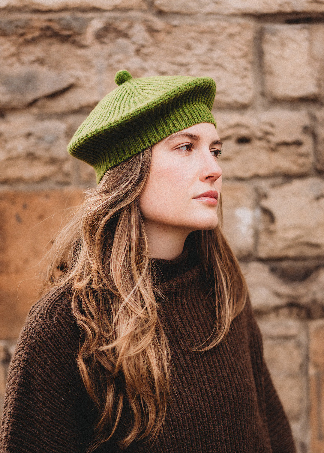 Lambswool beret in moss green, finished with a felted pom-pom on top.